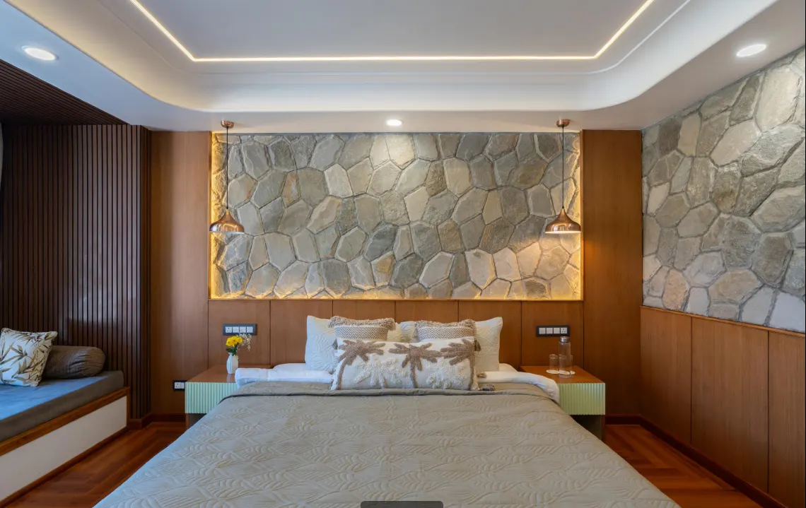 Bed in a Premium Room beside the stone wall